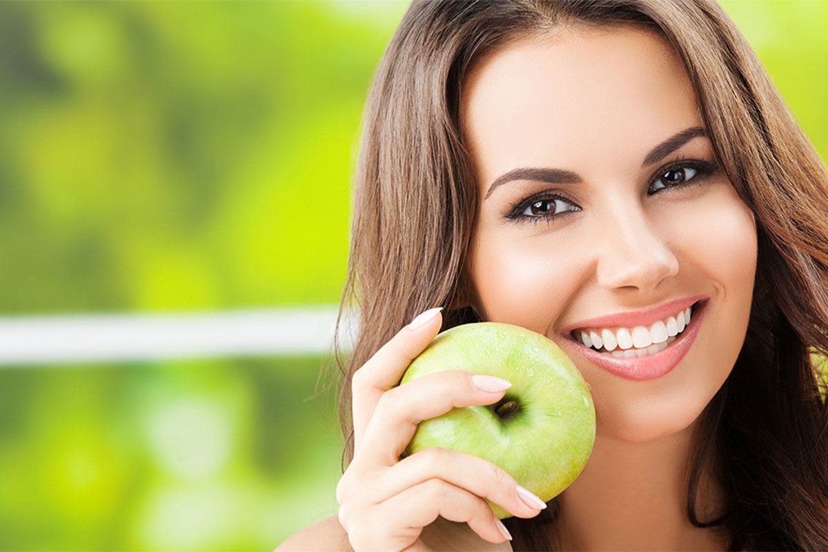Girl smiling with an apple